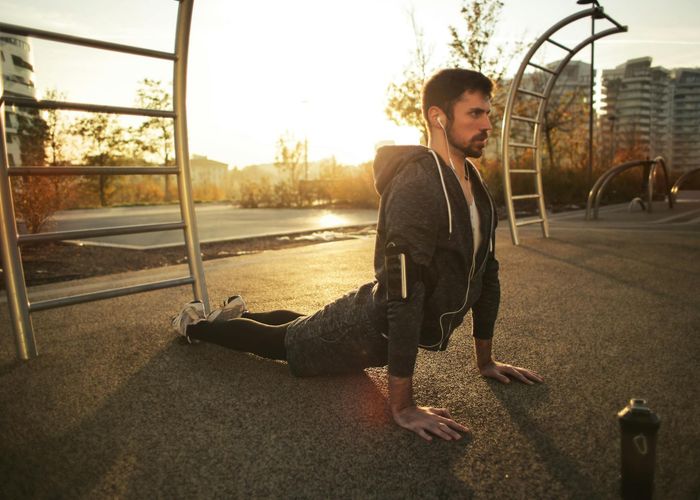 Man stretching outdoors feeling revitalized and energetic at sunrise.